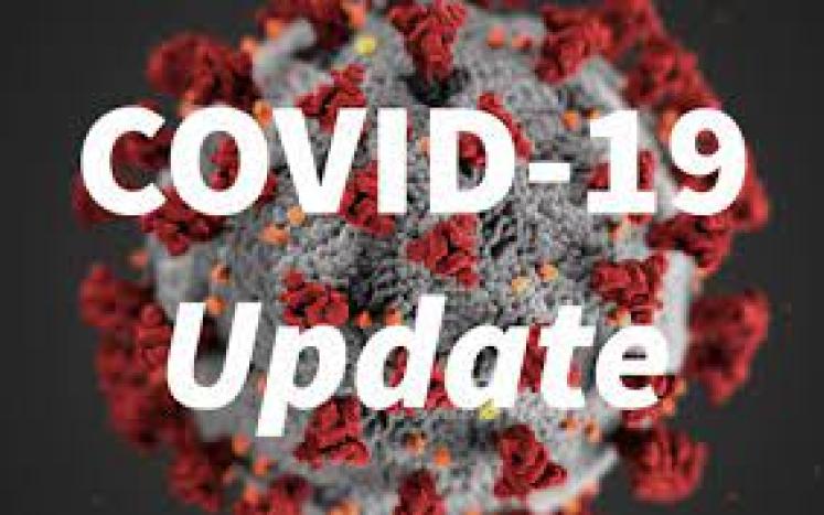 graphic of coronavirus with text in front saying COVID-19 Update